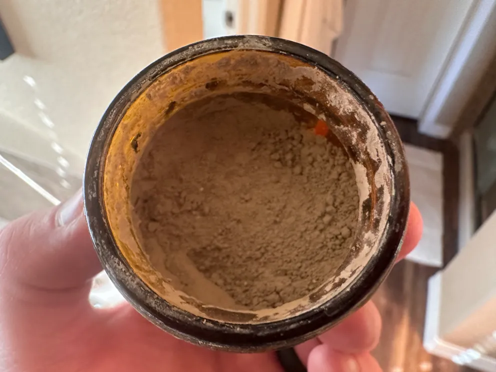 Close up of my opened jar of Akamai toothpowder showing the grey mineral clay texture